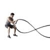 Young man exercising with battling rope at gym