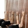 woman practicing yoga on ropes stretching in gym. Fit and wellness lifestyle.